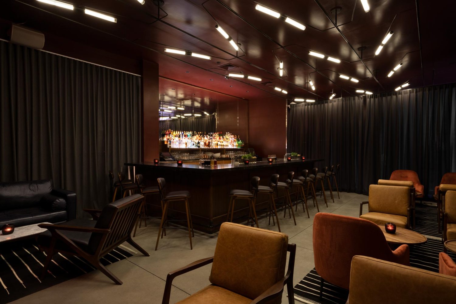 chairs, bar with liquor, dark room, stools