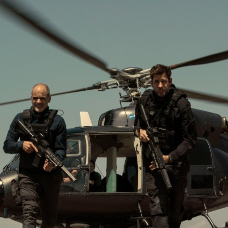 Jack Ryan walking from a helicopter with a gun.