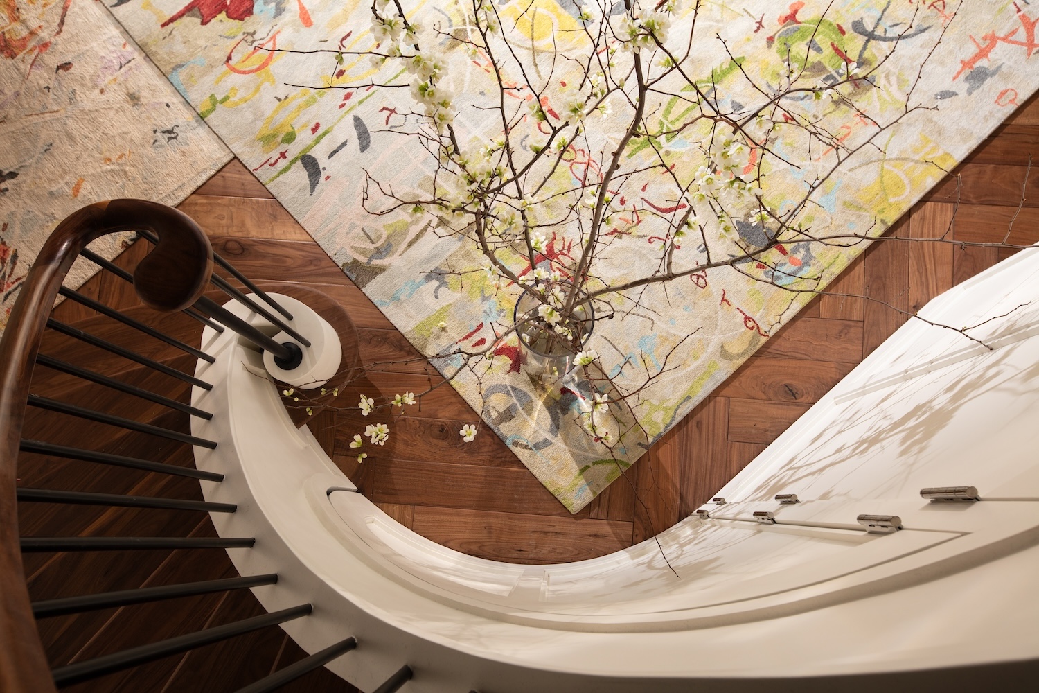 staircase, mulitcolored carpet, vase with flowers