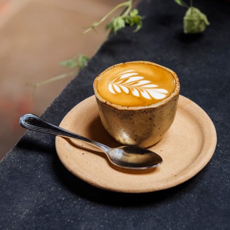 latte on a plate next to a spoon