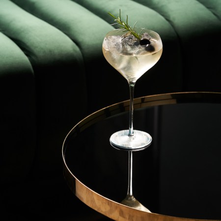 Classic cocktail glass on glass table in night club restaurant, close-up