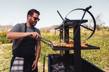 Micah Wexler cooking chicken on a grill.