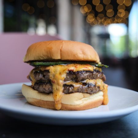 burger with two beef patties, melted cheese, and lettuce